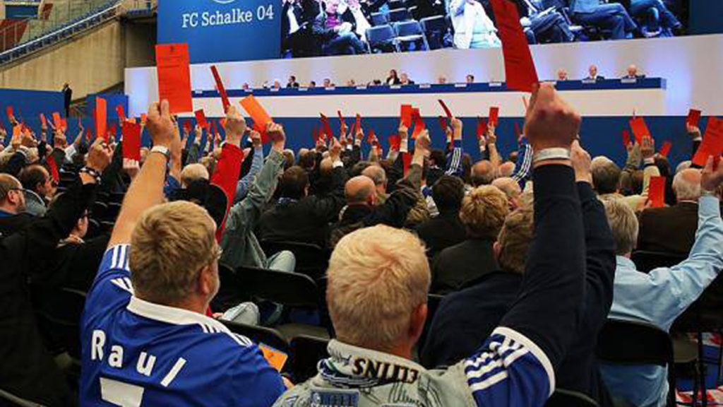 Mitgliederversammlung auf Schalke, Mitglieder halten rote Stimmkarten hoch